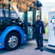 Bacher-Reisen Busfahrer vor E-Bus und EnerCharge CompactCharger